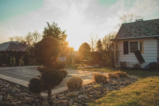 A Bright Orange Sunset in a Suburban Backyard With Trees and Rocks