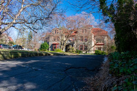 A Large Estate Like Property With a Large Driveway on a Clear Blue Sky