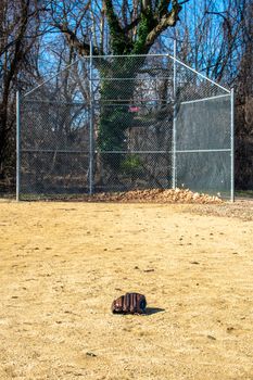 A Forgotten Baseball Glove on a Sand Baseball Field