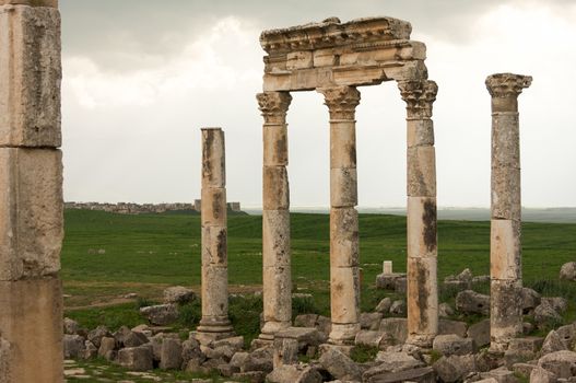 Apamea, Syria - May, 2009: Syria before the war. the Great Colonnade and triumphal arches in the impressive Apamea Greek and Roman city of Apamea in Syria. Apamea was an ancient Greek and Roman city on the banks of the Orontes River in Syria. The site includes the famous Great Colonnade, one of the longest in the world. As a result of the ongoing civil war in Syria that started in 2011, the Apamea ruins have been damaged and looted by treasure hunters.