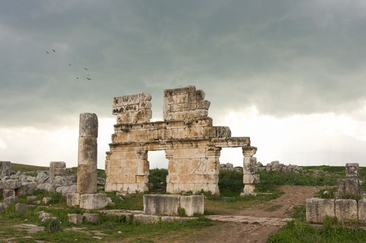 Apamea, Syria - May, 2009: Syria before the war. the Great Colonnade and triumphal arches in the impressive Apamea Greek and Roman city of Apamea in Syria. Apamea was an ancient Greek and Roman city on the banks of the Orontes River in Syria. The site includes the famous Great Colonnade, one of the longest in the world. As a result of the ongoing civil war in Syria that started in 2011, the Apamea ruins have been damaged and looted by treasure hunters.