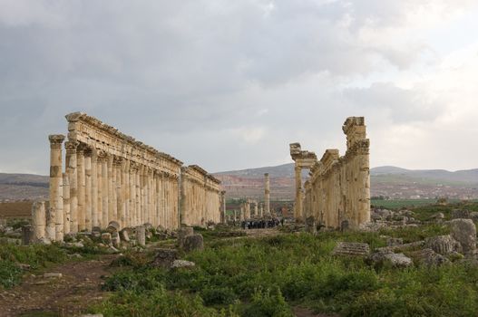 Apamea, Syria - May, 2009: Syria before the war. the Great Colonnade and triumphal arches in the impressive Apamea Greek and Roman city of Apamea in Syria. Apamea was an ancient Greek and Roman city on the banks of the Orontes River in Syria. The site includes the famous Great Colonnade, one of the longest in the world. As a result of the ongoing civil war in Syria that started in 2011, the Apamea ruins have been damaged and looted by treasure hunters.