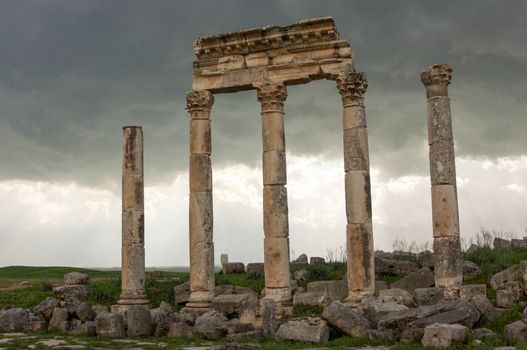 Apamea, Syria - May, 2009: Syria before the war. the Great Colonnade and triumphal arches in the impressive Apamea Greek and Roman city of Apamea in Syria. Apamea was an ancient Greek and Roman city on the banks of the Orontes River in Syria. The site includes the famous Great Colonnade, one of the longest in the world. As a result of the ongoing civil war in Syria that started in 2011, the Apamea ruins have been damaged and looted by treasure hunters.