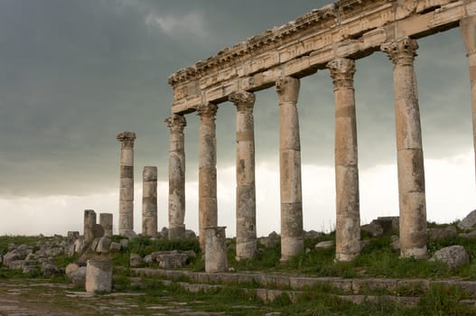 Apamea, Syria - May, 2009: Syria before the war. the Great Colonnade and triumphal arches in the impressive Apamea Greek and Roman city of Apamea in Syria. Apamea was an ancient Greek and Roman city on the banks of the Orontes River in Syria. The site includes the famous Great Colonnade, one of the longest in the world. As a result of the ongoing civil war in Syria that started in 2011, the Apamea ruins have been damaged and looted by treasure hunters.