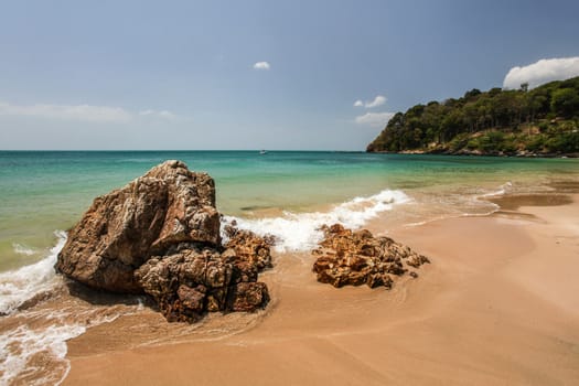 Klong Nin beach, with rocks in foreground and green blue sea in background. Koh Lanta, Thailand