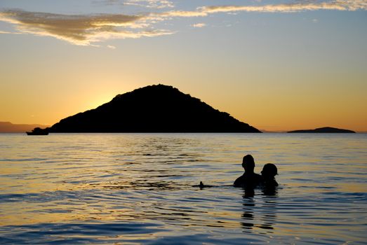 Silhouette of a couple swimming in Lake Malawi at sunset, Malawi