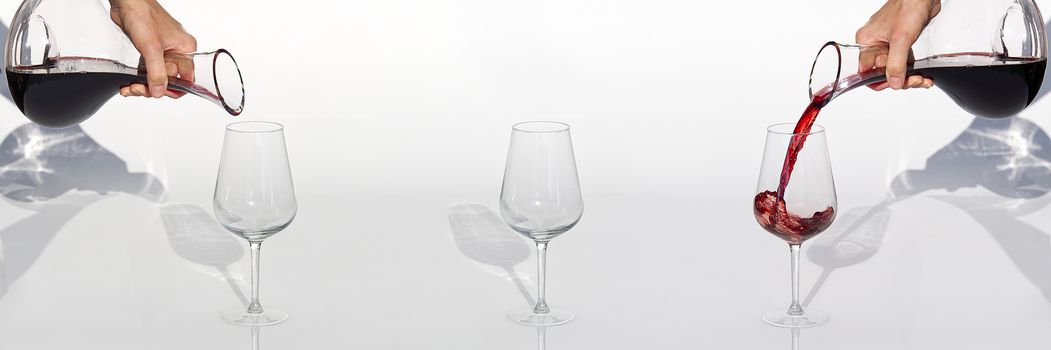 Sommelier pours red wine from decanter to wineglass on white background. panoramic shoot or banner