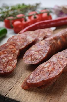 Traditional chorizo cuts with spices and ingredients on white surface.