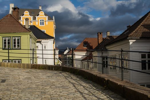 Bergen, Norway, May 2015: Old town street scene, or Gamle Bergen, with houses and dark rain clouds.