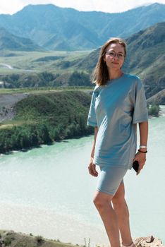 Domestic tourism, travel, lesure and freedom concept after pandemic- woman on the confluence of two rivers Katun and Chuya in Altai mountains, beauty summer day