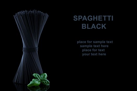 Black spaghetti with fresh green basel leaves with reflection on black background and place for text.