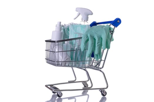 Shopping cart filled with different kinds of desinfectants on white background.