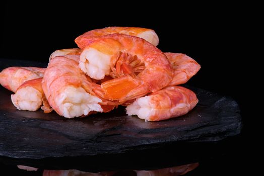 Healthy diet food: boiled wild tiger shrimps close-up on a plate on a table.