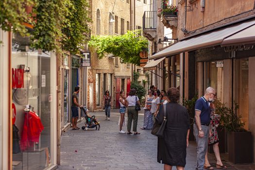 TREVISO, ITALY 13 AUGUST 2020: People walking in Treviso alley in Italy