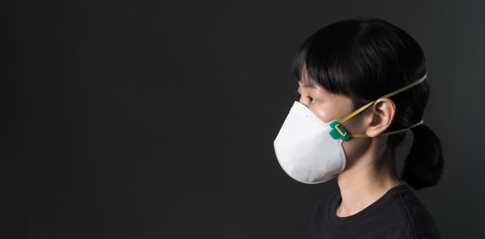 Middle aged of asia chinese woman wearing medical N95 mask that help prevent or protect her from coronavirus or covid-19 pandemic and safety from air pollution. and copy space