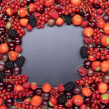 Berries upstairs closeup of colorful assorted mix as a background with a place for inscription.