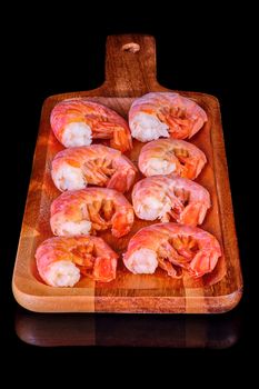 Healthy diet food: boiled wild tiger shrimps close-up on a plate on a table.