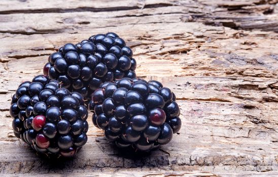 Three Large Blackberry Macro on old wooden background.