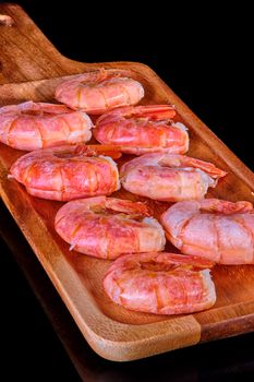 Healthy diet food: boiled wild tiger shrimps close-up on a plate on a table.