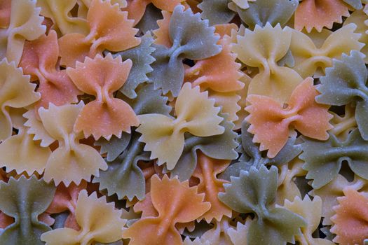 Colorful Italian raw pasta Farfalle Close up. Uncooked pasta .Italian egg pasta as background.