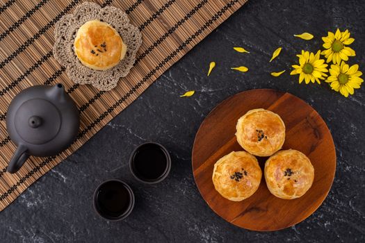 Moon cake yolk pastry, mooncake for Mid-Autumn Festival holiday, top view design concept on dark wooden table with copy space, flat lay, overhead shot