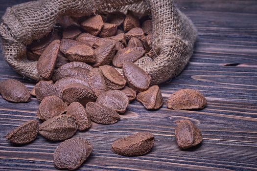 Paranuts in bag, vegetarian food in wooden bowls, on old wooden background.