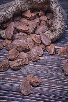 Paranuts in bag, vegetarian food in wooden bowls, on old wooden background.