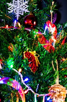 Christmas hanging decorations on fir tree. Decorated Christmas tree. Fir branch with Christmas baubles decorations.