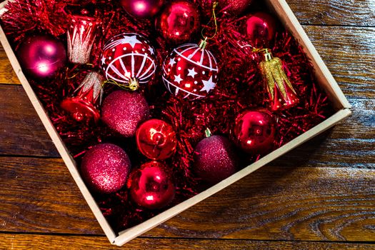 Christmas decorations and ornaments in a box. Box with red Christmas balls and garlands.