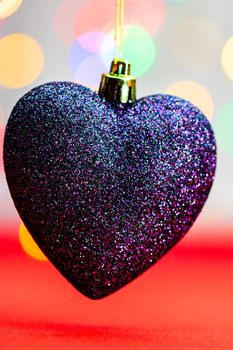 Heart shaped Christmas decoration isolated on blurred background of lights.