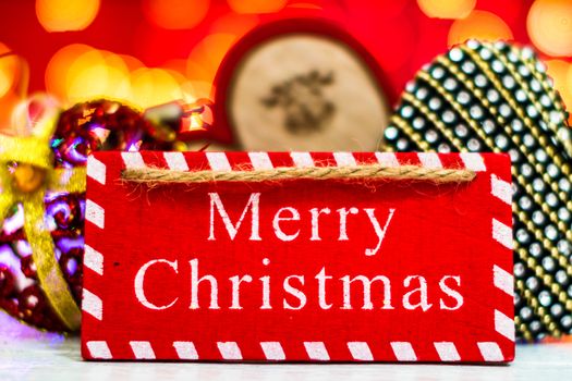 Merry Christmas text wooden sign, decorations and ornaments in a colorful Christmas composition.