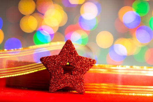 Red glittery decoration in a colorful Christmas composition isolated on background of blurred lights.