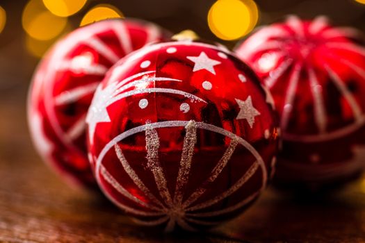 Red Christmas balls isolated on blurred and shiny background of lights. Christmas baubles isolated.