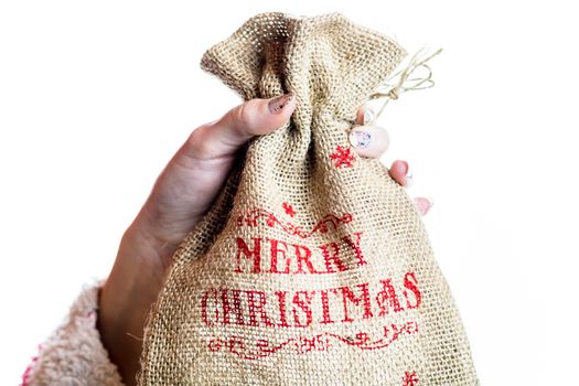 Hand holding Christmas burlap sack isolated on white background