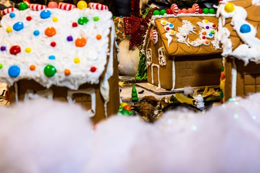 Colorful gingerbread house isolated on blurred background with Christmas decoration.