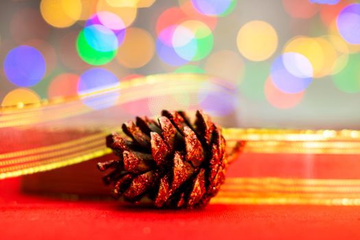 Red glittery decoration in a colorful Christmas composition isolated on background of blurred lights.