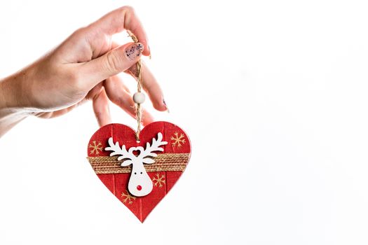Hand holding heart shaped Christmas decoration isolated on white.