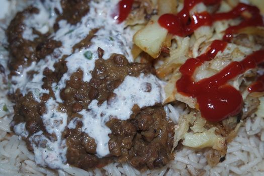 Delicious traditional dish of rice with potato fries and cereals with red ketchup. Food background with copy space for text and advertisements.