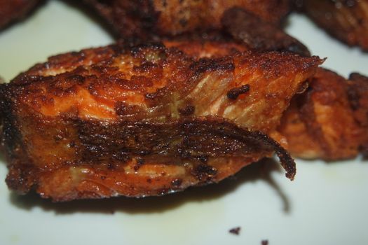 Spicy and crunchy barbecue of fried fish fillet on a white background. Homemade grilled trout fish steaks for health nourishments.