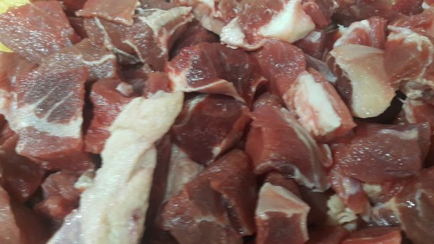 Close up view of fresh finely chopped meat cubes. Red meat small steaks with whitish meat fat.