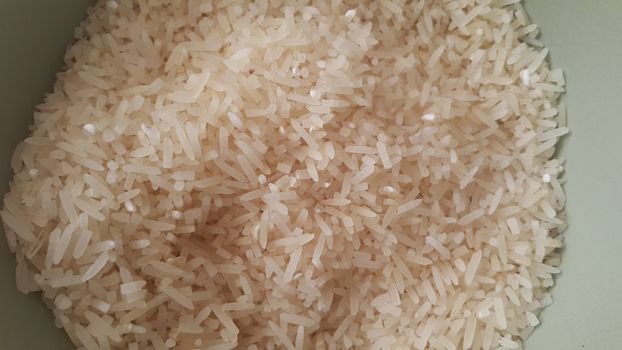 Top closeup view of heap of rice. Rice is the most consumed food ingredient in the world