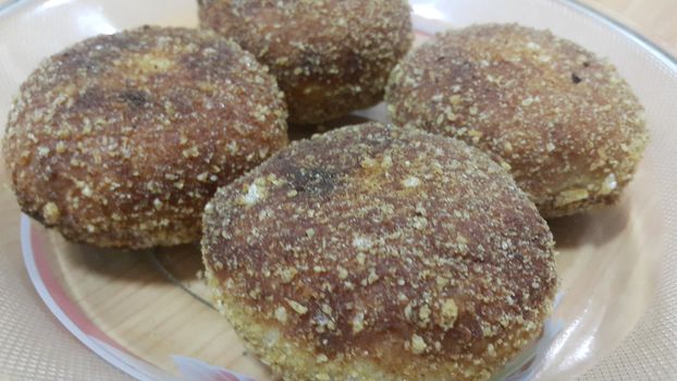 Closeup perspective view of fried pizza bomb or pizza balls served in a glass plate over wooden floor. Pizza bombs are delicious and tasty altered form of pizza.