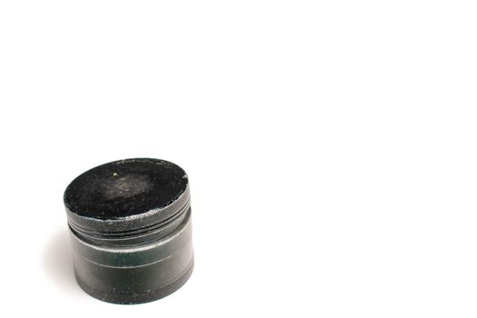 A Used Black Cannabis Grinder With the Lid On Top But Slightly Ajar