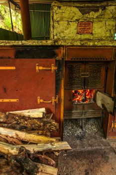 Kandy, Sri Lanka - April 12th, 2017: Fire burning in old Sirocco heater oven. This vintage oven (manufactured by Davidson & Co, Belfast, Ireland) is still used to dry tea in Kadugannawa Tea Factory