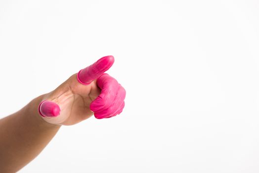 Woman hand wearing pink finger cots rubber protect help prevent fingerprints on the finger touched piece with poinging finger, studio shot isolated on white background