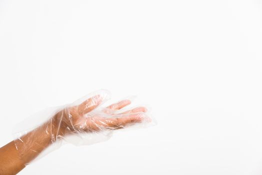 Woman hand wearing single use protect disposable transparent plastic glove, studio shot isolated on white background