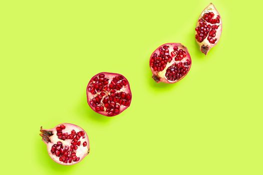 Top view of ripe pomegranate fruit on green background.