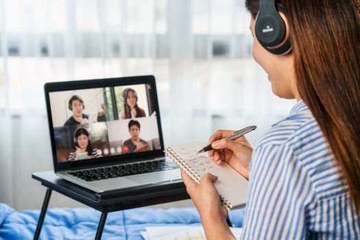 Rear view of Asian woman working and online meeting via video conference with colleague and team building when Covid-19 pandemic,Coronavirus outbreak,education and Social distancing,new normal concept