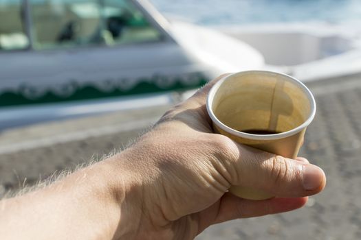 Smallest coffee in the world in Malé in the Maldives. Man holds coffee mug in hand.