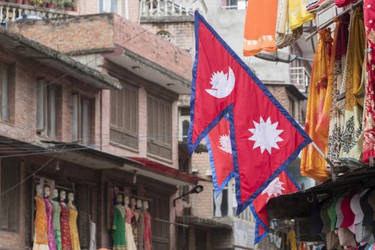 Red, blue flag, flag of country Nepal in the middle of a city in Kathmandu, Nepal.